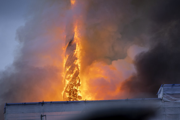 Fire and smoke rises up along the spire of Copenhagen’s Old Stock Exchange.