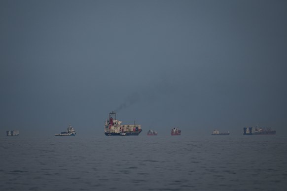 Oil tankers and cargo ships line up in the Strait of Hormuz as seen from Khor Fakkan, United Arab Emirates.