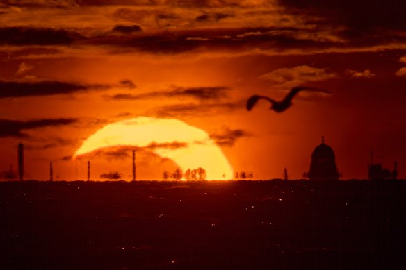 The moon and the sun set in the Gulf of Finland, seen from St. Petersburg, Russia.