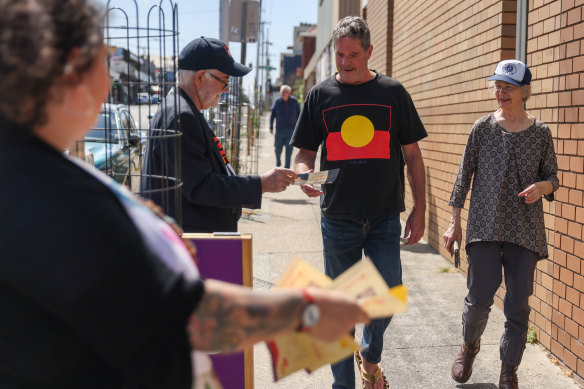 Volunteers hand “how to vote” cards outside a polling booth on Monday at Thornbury in Melbourne.