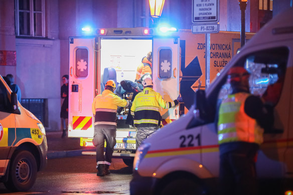 Paramedics load a stretcher into an ambulance at the location of the shooting in Prague. 