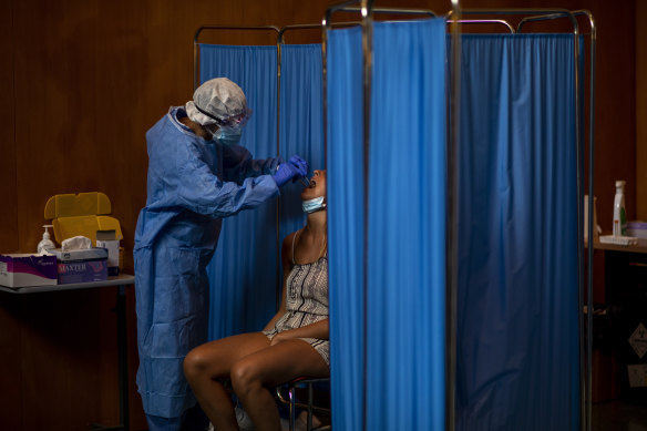 A medical worker tests a woman for COVID-19 in Barcelona this week.