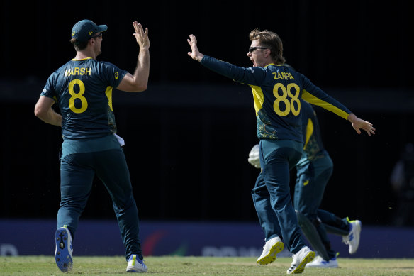 Adam Zampa and Mitchell Marsh celebrate after Australia took the wicket of England captain Jos Buttler.