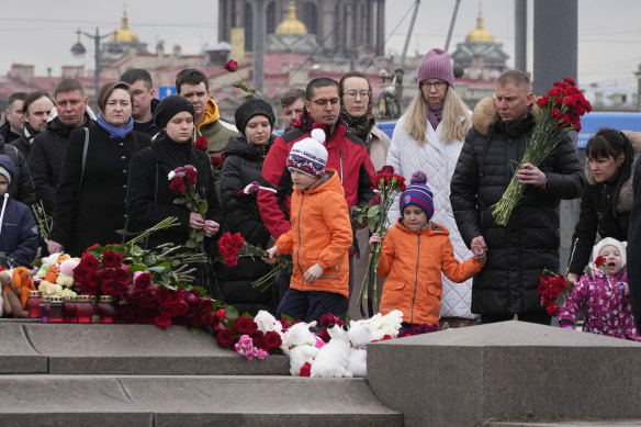 People lay flowers at a spontaneous memorial in St Petersburg on Sunday (local time). 
