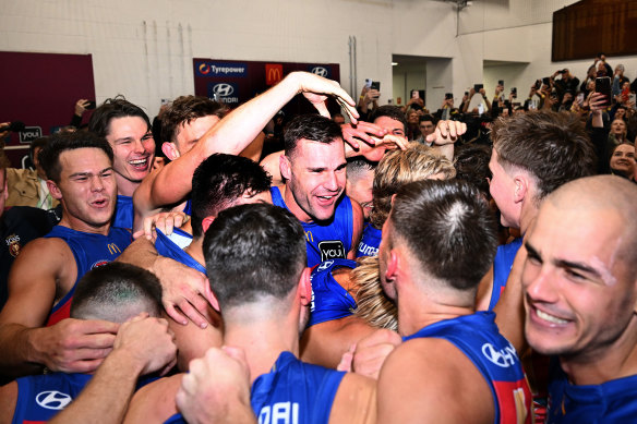  Jack Payne of the Lions, middle, celebrates victory with teammates following the win over Geelong.