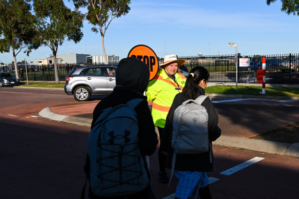 Crossing supervisor Christine Pelham assists students on Thursday morning.