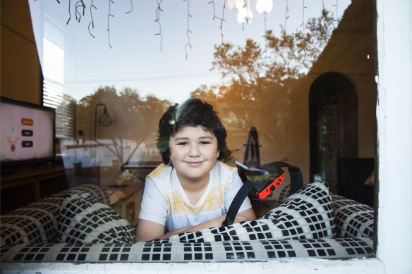 Alonso Zambrano peers out of a window of his Panania home. 