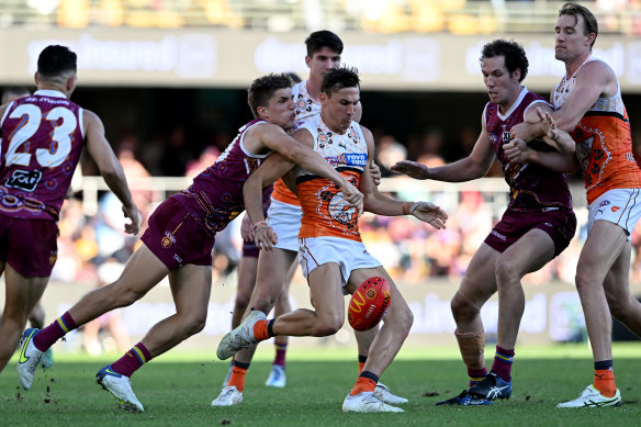 GWS’s Isaac Cumming gets a kick away under pressure at the Gabba.