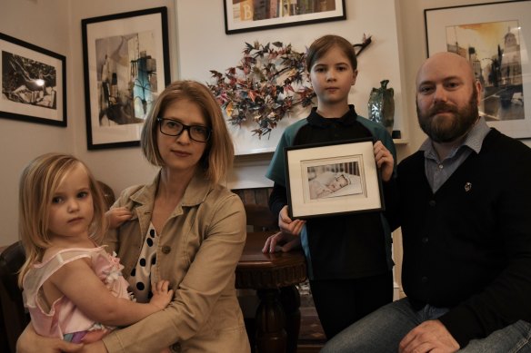 Alice Neikirk and Ray Nickson with their daughters Cynthia Nickson, 10, and Heidi Nickson, 2, and a portrait of their daughter Edna, who died after traumatic case of medical negligence.