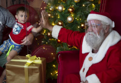 A child greets Santa through a plastic shield in a shopping centre in Johannesburg, South Africa.