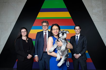 Jo Cooper holds her dog Angus, and stands with her lawyer Sharon Levy from Bartier Perry Lawyers and barristers Robert Newlinds and Robert Pietriche in the foyer of the prestige apartment tower The Horizon. 