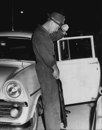 Det. Colin Leatherbarrow recovers after he had raced from the house after the tear-gassing. December 13, 1961.