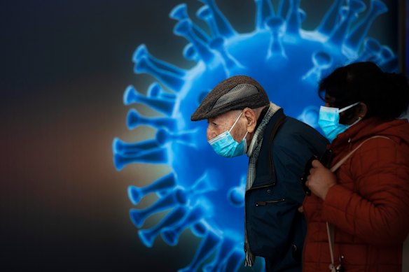 People wearing face masks wait to receive a coronavirus vaccine at a COVID-19 vaccination centre in Jerusalem on Monday.