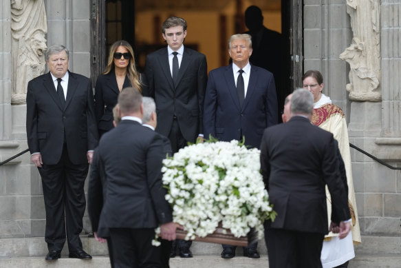 Former president Donald Trump, centre right, stands with Melania as the coffin carrying the remains of her mother is carried into the church for her funeral, in Palm Beach, Florida.