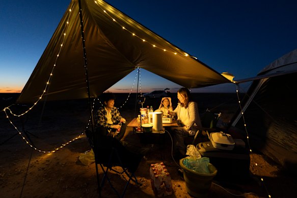 Li Dan (right) cooks dinner for her daughter and son as they wait for nightfall in Inner Mongolia.