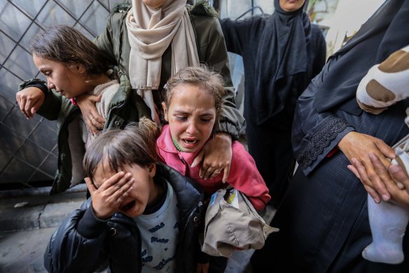 Palestinians mourn while receiving the bodies of victims of an Israeli strike on Rafah.