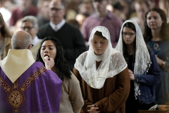 People receive communion during Catholic Mass at Benedictine College in Kansas.