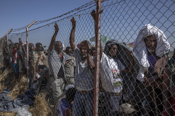 Tigray men who fled the conflict in the Ethiopia's Tigray region, wait for UNHCR to distribute blankets at Hamdayet Transition Centre, eastern Sudan.