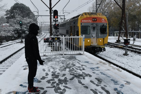 A V-set train travels through the Blue Mountains in winter.