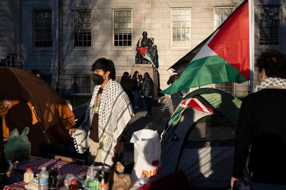 A student protester stands in front of the statue of John Harvard, the first major benefactor of Harvard College.