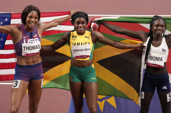 Elaine Thompson-Herah (centre) celebrates gold in the 200m alongside Gabrielle Thomas and Christine Mboma.