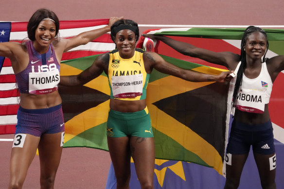 Elaine Thompson-Herah (centre) celebrates gold in the 200m alongside Gabrielle Thomas and Christine Mboma.