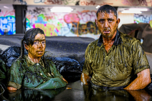 Down and dirty: Angus Cerini and Nicci Wilks perform part of THIS in a pool of mud.