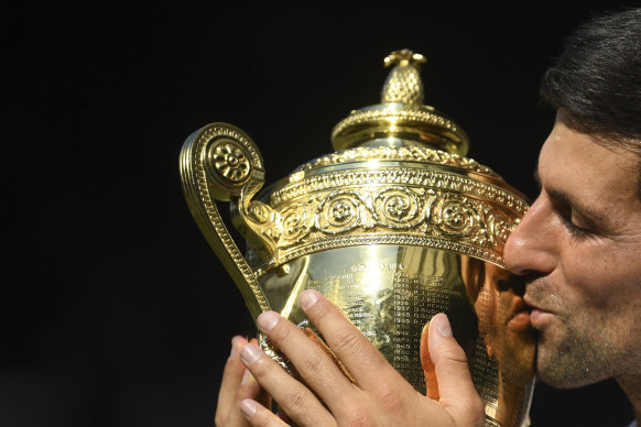 Golden boy: Novak Djokovic of Serbia kisses the trophy after defeating Kevin Anderson.