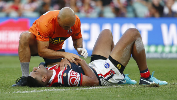 Down and out: Daniel Tupou of the Roosters receives medical attention on-field.