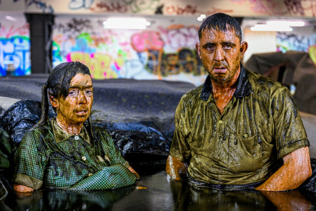 Down and dirty: Angus Cerini and Nicci Wilks perform part of THIS in a pool of mud.