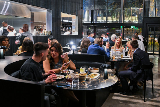 The Saint’s dining room is hemmed in by red brick and walls of glass, with black marble tabletops lit by tiny lamps.