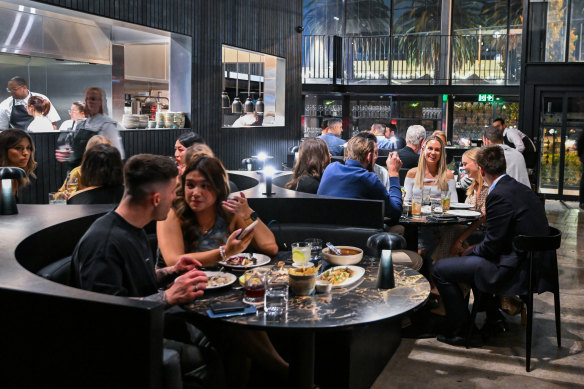 The Saint’s dining room is hemmed in by red brick and walls of glass, with black marble tabletops lit by tiny lamps.