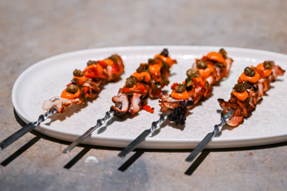 Fremantle octopus skewers with roasted peppers, harissa and puffed capers.