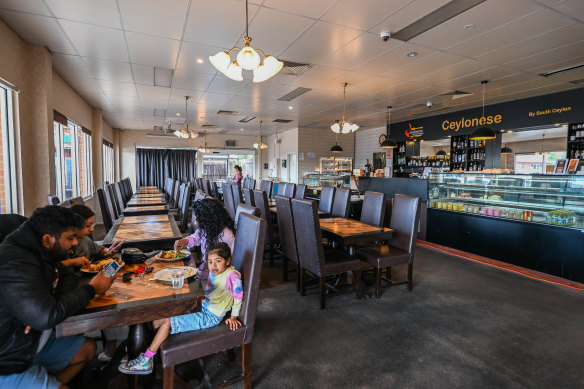 The buffet restaurant has two rows of tables and high-backed padded chairs.