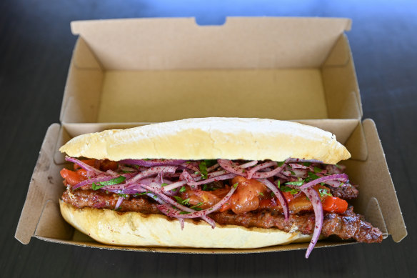 Adana kebab roll with barbecued tomatoes, bullhorn peppers and sumac red onions.