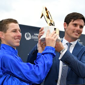 Damian Lane and trainer James Cummins lift the Golden Slipper after Kiamichi's upset win.