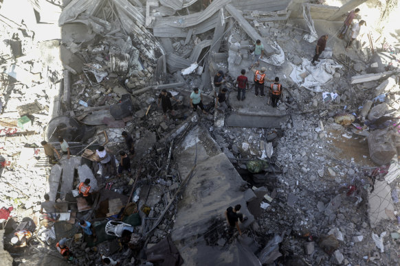 Palestinians look for survivors under the rubble of a destroyed building following an Israeli airstrike in Khan Younis refugee camp, southern Gaza Strip.