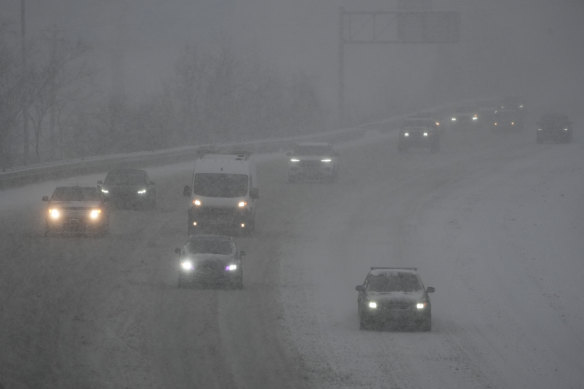 Des véhicules circulent sur une autoroute pendant une tempête hivernale dimanche à Cincinnati.