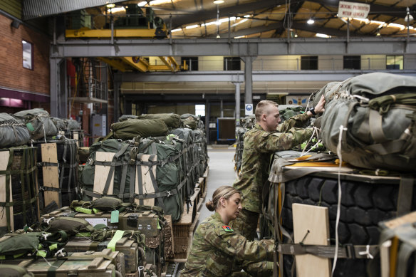 New recruits Private Hannah Gribble and Private Joel Scott check cargo loads that will be dropped by a C130H Hercules during a training mission at the RAAF base at Richmond.