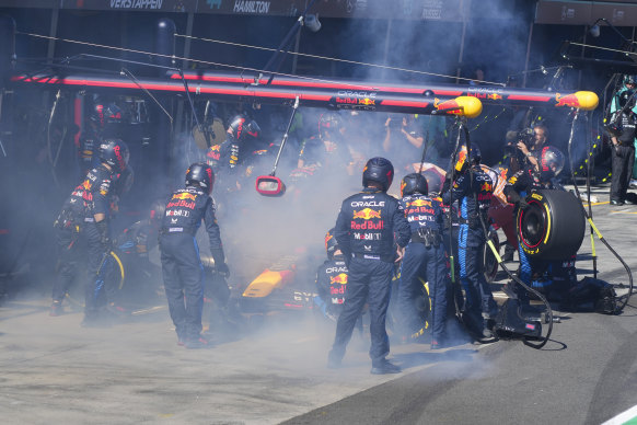 Mechanics work to extinguish the fire that broke out in Red Bull driver Max Verstappen’s car on the fourth lap of the race.