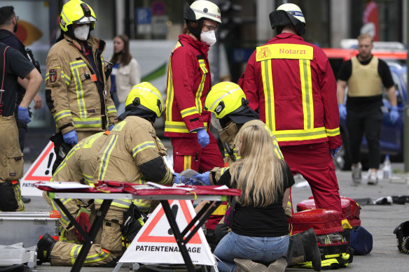 Rescuers help an injured person after a car crashed into a crowd of people in Berlin.