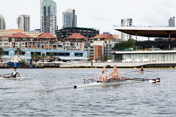 Students Josie Lehmann and Isla Eade pass in front of the old and new fish market buildings on Blackwattle Bay.