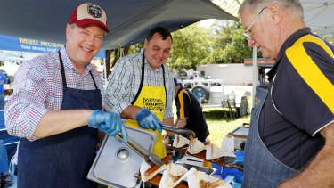 Queensland Opposition Leader Tim Nicholls helps out with a sausage sizzle during a visit to Redland Bay market on Sunday.