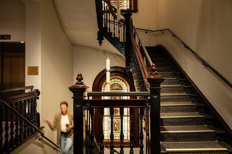 A grand staircase leads past stain-glass windows to the second level.