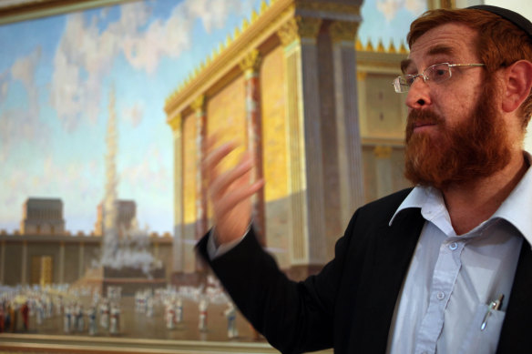 Rabbi Yehuda Glick stands next to an artist's impression of the Jewish Temple, deemed to have stood on what is now the site of al-Aqsa mosque.