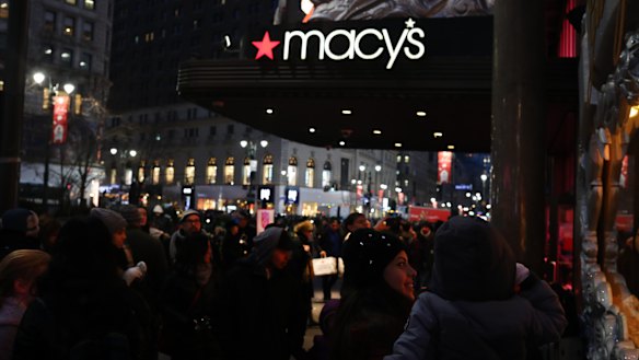 Pedestrians pass in front of a Macy's Inc. department store in New York.