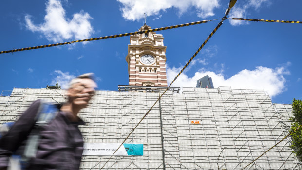 The tower clock has been unveiled as much of Flinders Street Station's facade lies under scaffold.