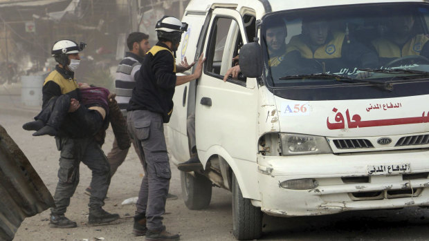A civil defence worker carrying a victim after airstrikes hit a rebel-held suburb near Damascus on  Thursday.