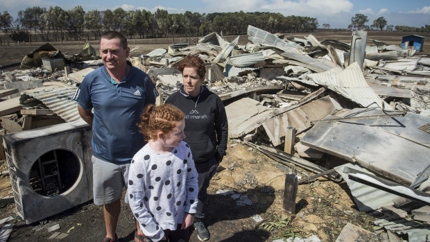Phil and Maree Beasley with their 11-year-old daughter, Rose, amid the wreckage of their Terang home.