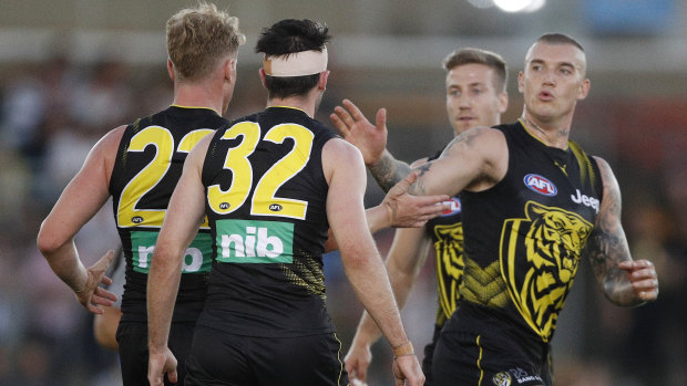 Josh Caddy (left) celebrates a goal with Tigers teammate Dustin Martin during their JLT Community Series match against North Melbourne on Wednesday night.